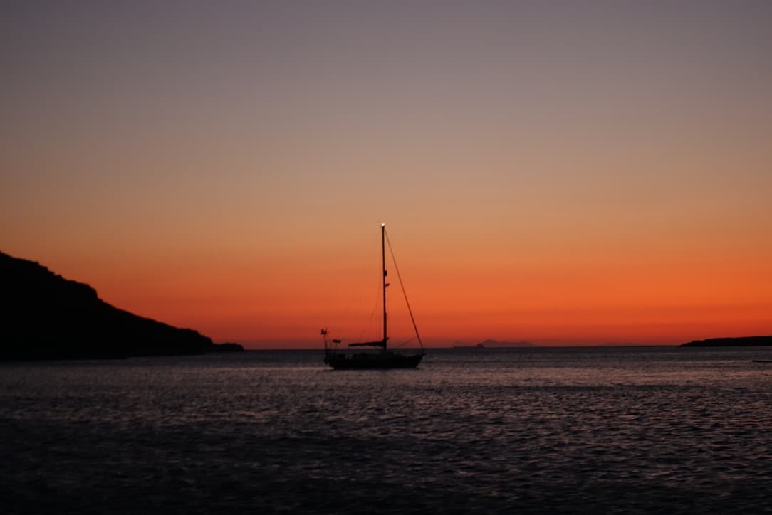 sailing boat anchored in a sunset